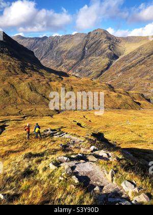 Marcheurs sur le chemin et les pentes de Munro Buachaville Etive Beag, avec vue sur la crête d'Aonach Eagach, Glencoe, Écosse Banque D'Images