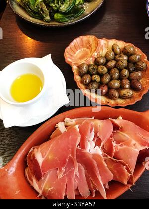 Sélection de tapas jambon cru, olives, huile d'olive et poivrons verts frits Banque D'Images