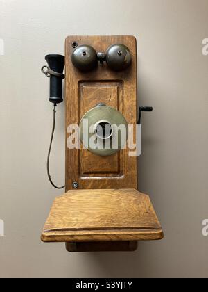 Ancien téléphone en bois qui est suspendu au mur et ressemble à un visage Banque D'Images