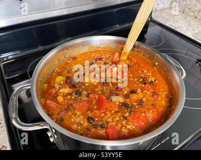 Chili de dinde de citrouille maison dans une casserole sur une cuisinière de cuisine. Banque D'Images