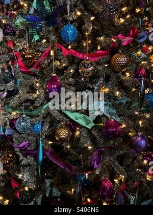 Boules colorées et guirlande dans un sapin de Noël décoré Banque D'Images