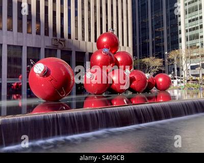 D'énormes décorations rouges de vacances sur 6th Ave., Avenue of the Americas, dans le centre-ville de Manhattan, New York avec une longue exposition sur la partie de la cascade Banque D'Images