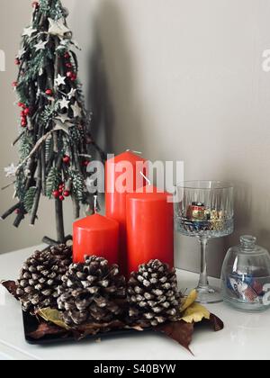 Décorations de Noël - bougies rouges, arbre de Noël, cône de pin et bols de chocolat Banque D'Images