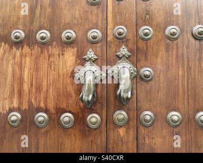 Main de Fatima porte knockers sur une ancienne porte en bois Banque D'Images