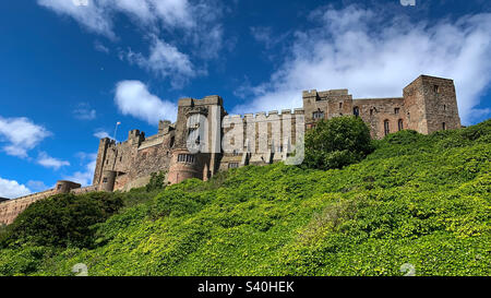 Vue sur l'imposant château de Bamburgh lors d'une journée ensoleillée d'été, Northumberland, Royaume-Uni Banque D'Images