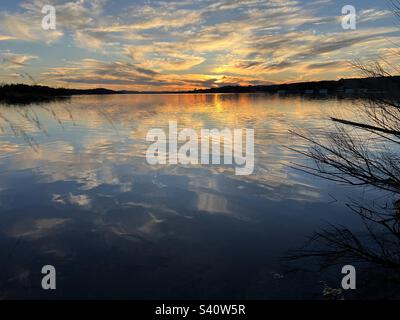 Coucher de soleil sur le lac Inks. Situé dans le parc national d'Inks Lake, Texas. Célébration de 100 ans dans les parcs nationaux du Texas. Le beau reflet des rayons du soleil comme ses rayons dorés se reflètent au large du lac. Banque D'Images