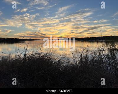 Coucher de soleil sur le lac Inks. Situé dans le parc national d'Inks Lake, Texas. Célébration de 100 ans dans les parcs nationaux du Texas. Le beau reflet des rayons du soleil comme ses rayons dorés se reflètent au large du lac. Banque D'Images