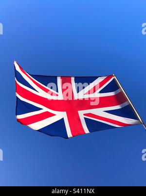 Un Union Jack volant fièrement contre un ciel bleu vif Banque D'Images
