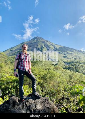 Un homme se tient devant un grand volcan par temps clair près de la Fortuna au Costa Rica Banque D'Images