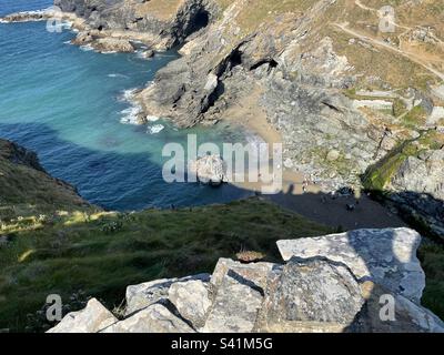 Tintagel Haven Beach depuis le sommet des falaises du château de Tintagel, en Cornouailles, en Angleterre, lors d'une chaude journée d'été Banque D'Images