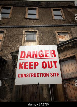 Panneau danger : ancien bâtiment abandonné en cours de rénovation, maintenant un chantier de construction au Royaume-Uni Banque D'Images