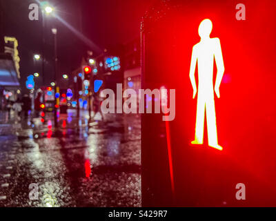 Lumière rouge à la traversée piétonne la nuit dans le centre-ville Banque D'Images