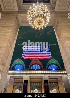 Architecture intérieure du grand terminal central de New York avec un grand drapeau américain et un lustre luxueux. Photo prise à New York en décembre 2022 Banque D'Images