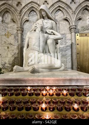 Statue religieuse avec bougies allumées en face à St. Cathédrale de Patrick à New York. Photo prise à New York en décembre 2022 Banque D'Images