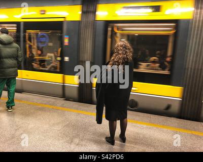 Lady à la station de Trindade du réseau métropolitain de Porto attendant que le train s'arrête, Portugal, 2023 Banque D'Images