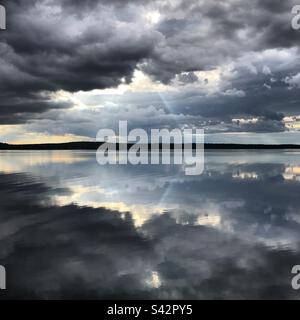 Couvaison de nuages de tempête sombres dans un grand lac de la région de Kajaani en Finlande pendant un été arctique Banque D'Images