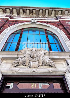 Vue sur l'entrée de l'ancien bâtiment à Norwich, dans le centre-ville du Connecticut. Architecture en brique rouge avec arche et fenêtre. Avec sculpture en pierre d'aigle et symboles de récolte. Banque D'Images