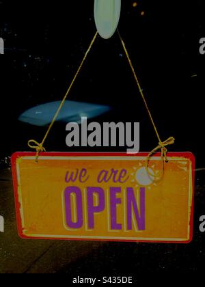 Affiche suspendue orange et rose, indique OUVERTE sur fond noir. Inclut l'espace d'impression. Banque D'Images