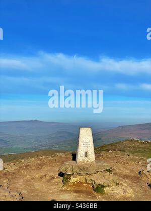 Sommet point trigonométrique sur la montagne Sugarloaf, Abergavenny, Brecon Beacons, pays de Galles. Pen y Fan et Corn du visibles à distance. Banque D'Images