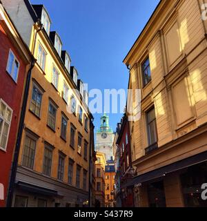 Les magnifiques extérieurs peints orange et jaune ombrageux des bâtiments traditionnels sur les rues étroites de la vieille ville de Stockholm Gamla Stan en Suède Banque D'Images