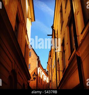 Les magnifiques extérieurs peints orange et jaune ombrageux des bâtiments traditionnels sur les rues étroites de la vieille ville de Stockholm Gamla Stan en Suède Banque D'Images