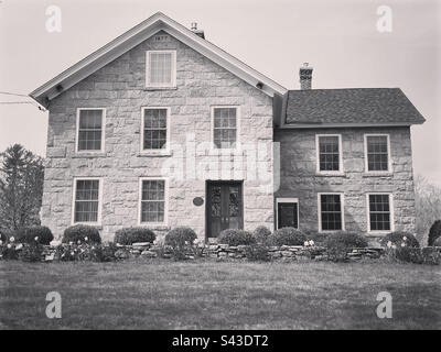 Belle maison en pierre ancienne à Waterford, Connecticut, États-Unis. Filtre noir et blanc. Construit en 1877 avec l'année notée au sommet de la ligne de toit. Banque D'Images