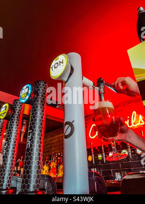 Une pinte de bière dans le bar à cocktails tendance en cours de versement Banque D'Images