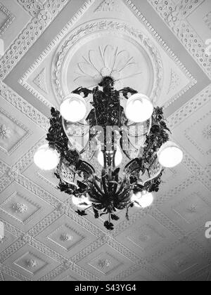 Plafond orné d'une lumière vintage suspendue. Intérieur d'un ancien manoir de domaine à Waterford, Connecticut, États-Unis. Parc régional Harkness Memorial. Filtre noir et blanc. Banque D'Images