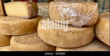 Des tranches de fromage, certaines enveloppées de film de clingfilm dans un magasin dans un marché de la rue française Banque D'Images