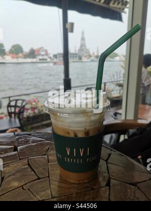 Boire du café glacé au café Vivi près de la rivière Chao Phraya à Bangkok, en Thaïlande. Banque D'Images