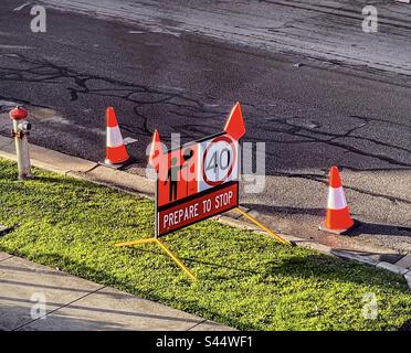 Des cônes de signalisation et un panneau d'avertissement sur la bande naturelle à côté de la route indiquent que la route avance et que la vitesse limite est de 40 km/h. Banque D'Images
