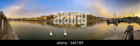 Vue panoramique sur le bar-restaurant flottant grain Barge avec des rangées de maisons colorées derrière, vue depuis la marina, au lever du soleil. ROYAUME-UNI Banque D'Images