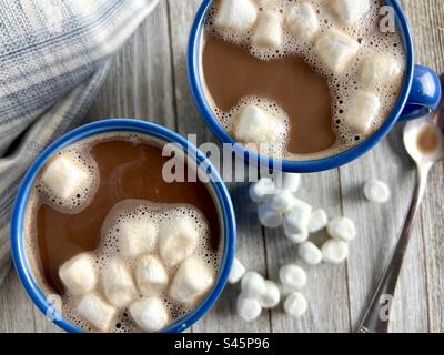 Chocolat chaud avec mini guimauves dans des tasses bleues Banque D'Images