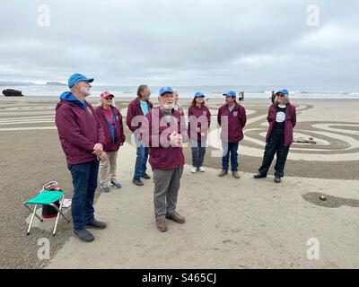 Denny Dyke, artiste de labyrinthe de sable, avec son équipe, s'adressant à la foule au début d'une promenade dans le labyrinthe à Bandon, Oregon Banque D'Images