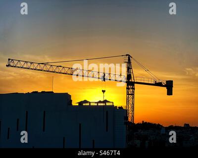 Silhouette d'une grue à tour au coucher du soleil Banque D'Images