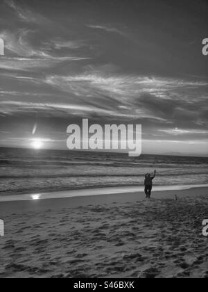 Image monochromatique de la plage de Lagoa de Albufeira, avec pêcheur au coucher du soleil. Sesimbra /Setubal, sud du Portugal. Banque D'Images