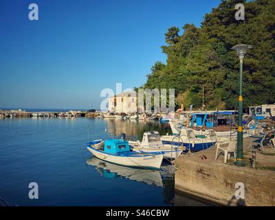 Vieux port avec des bateaux au coucher du soleil à Skala Potamias sur l'île de Thasos, Grèce. Banque D'Images