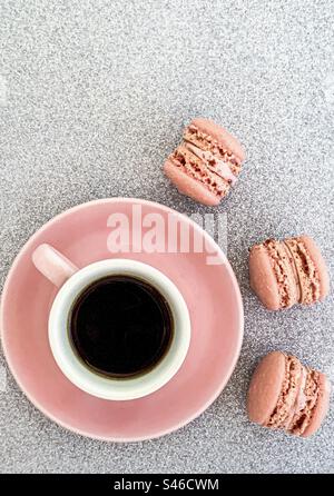 Tasse à café rose avec macarons roses sur fond argenté pailleté Banque D'Images