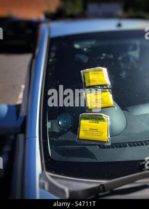 Une voiture garée avec trois tickets de stationnement Banque D'Images