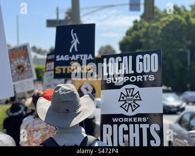 LOS ANGELES, CA, 15 AOÛT 2023 : membres de la section locale 600 de l'IATSE, syndicat de caméras, ligne de piquetage marchant en soutien aux écrivains et acteurs en grève, devant les portes des studios Paramount Pictures, Hollywood Banque D'Images