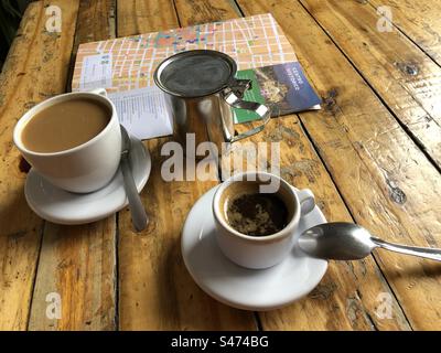 Une tasse d'espresso, une tasse de café et une carte avec écriture en espagnol sur la table rustique en bois, Mexico, 2022 Banque D'Images