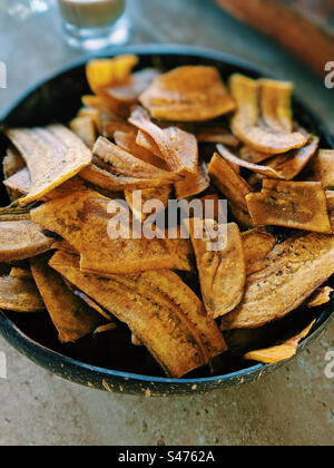 Gros plan de chips de banane séchées dorées dans un bol Banque D'Images