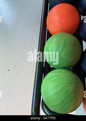 Trois boules de bowling colorées se trouvent dans une rangée Banque D'Images