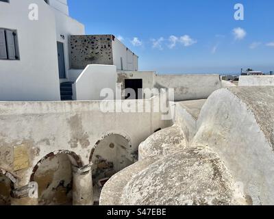 Vue architecturale intéressante des bâtiments traditionnels en roche blanchie à la chaux et volcanique du village de Megalochori sur l'île de Santorin. Banque D'Images