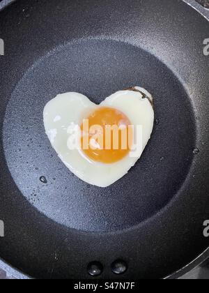 Oeuf frit en forme de coeur dans une petite poêle Banque D'Images