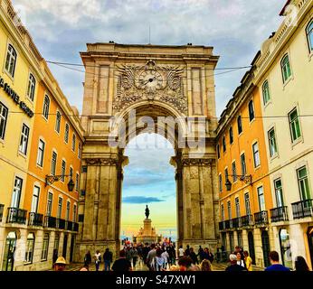 Marcher à travers Arco da Rua Augusta arcade à Lisbonne Portugal au coucher du soleil en regardant vers Praça do Comércio Banque D'Images