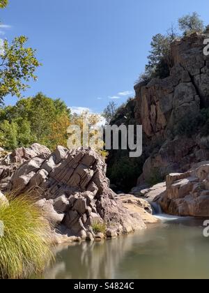 East Verde River falls, Water Wheel falls trail, pink granite rocks, early fall leaves, pines, bright blue sky, Payson, Arizona Stock Photo