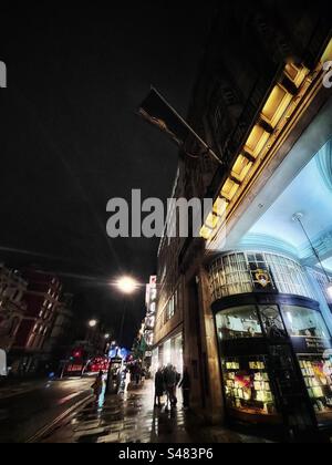 Regarder Piccadilly à Londres depuis Piccadilly Arcade la nuit par temps pluvieux Banque D'Images