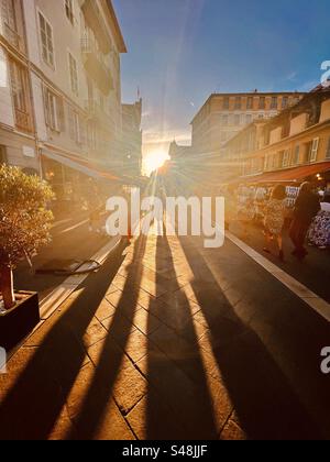 De longues ombres dramatiques de gens marchant dans la vieille ville de Nice à la fin de l'été au coucher du soleil Banque D'Images