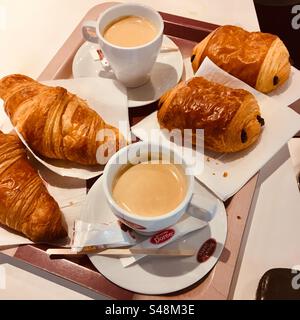 Deux croissants et deux croissants au chocolat avec café sur un plateau de petit déjeuner dans un restaurant en France Banque D'Images